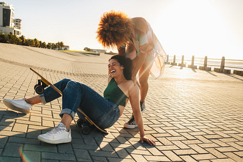 Lively young women laughing and enjoying a break from college with best friends outdoors