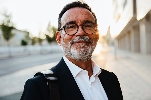 Confident senior businessman outdoors in the city during sunset