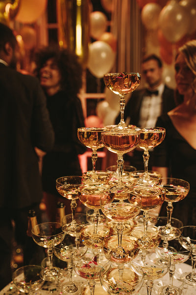 Pyramid of champagne with people partying around