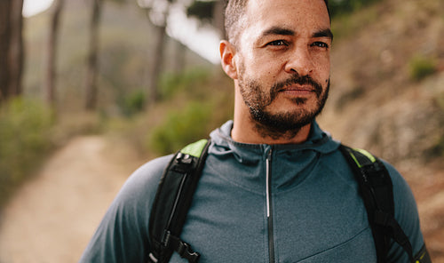 Fit young man standing on mountain trail