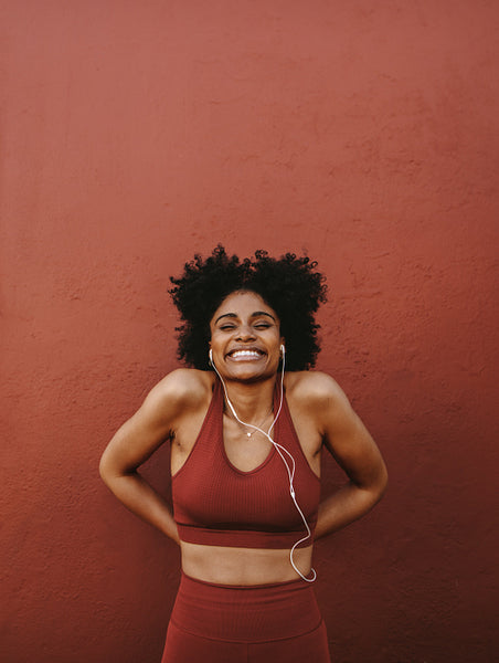 Healthy and fit woman standing by a wall