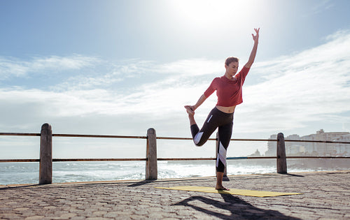 Active young woman doing yoga exercises