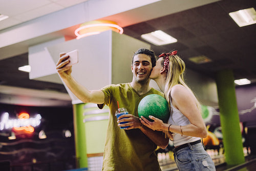 Loving couple taking selfie at bowling arena
