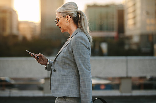 Businesswoman using smart phone on city street