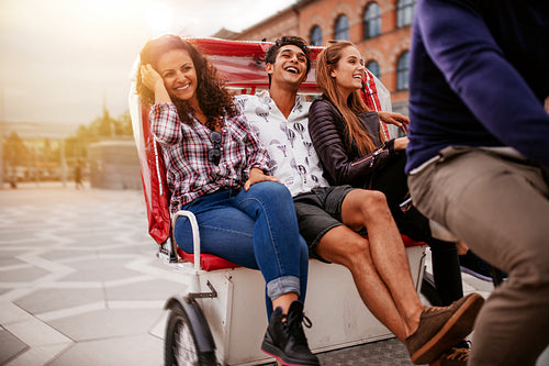 Teenage friends enjoying tricycle ride