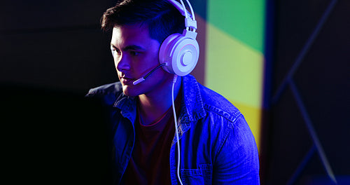 Male gamer playing a video game with a headset, engaging with online players and streamers