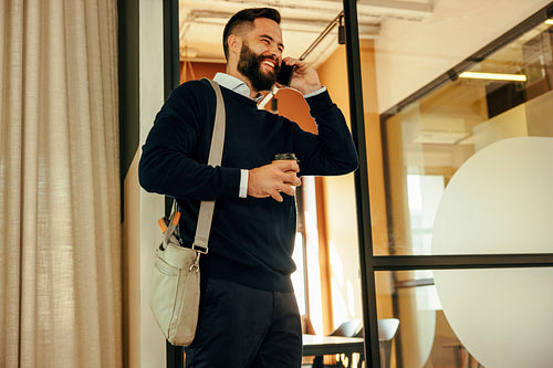 Happy businessman speaking on the phone in the morning