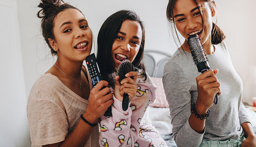 Three girls enjoying singing at a sleepover