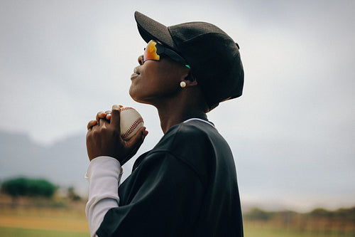 Professional female pitcher focusing intently while holding a baseball