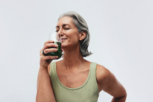 Woman in studio drinking healthy juice and wearing a smart ring