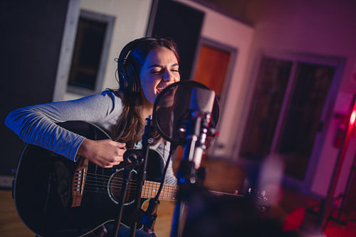 Female vocal artist singing in a recording studio