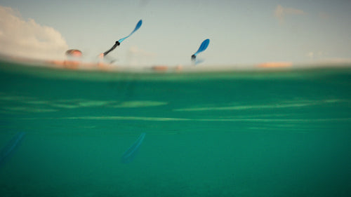 Family clear bottom kayaking in beautiful tropical ocean at sunset