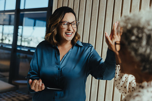 Success in business brings the team together for a high five during an office meeting