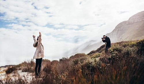 Man photographing his girlfriend during vacation