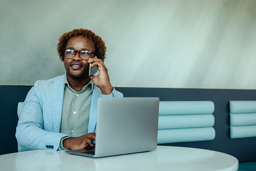 Friendly African salesperson making a call at the office