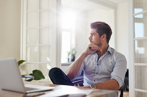 Thoughtful businessman sitting home office
