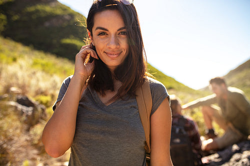 Female hiker with friends at back resting in countryside