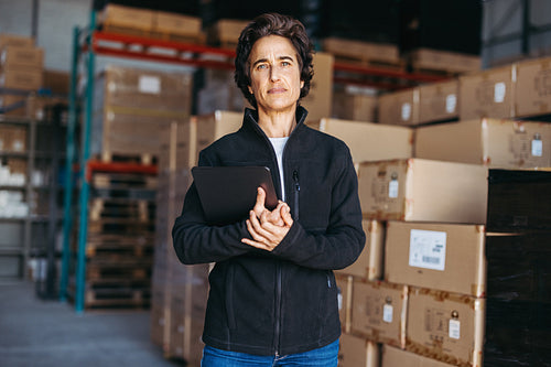 Mature woman looking at the camera in a distribution warehouse