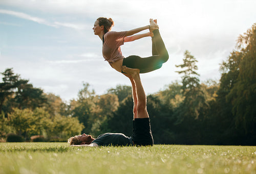 Fit young couple doing acro yoga