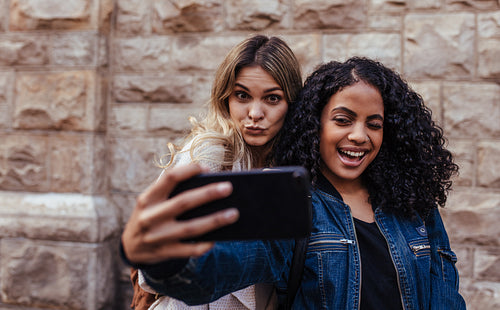 Two women posing for a selfie outdoors