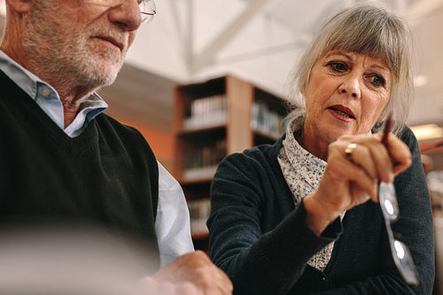 Close up of a senior couple discussing sitting in a library