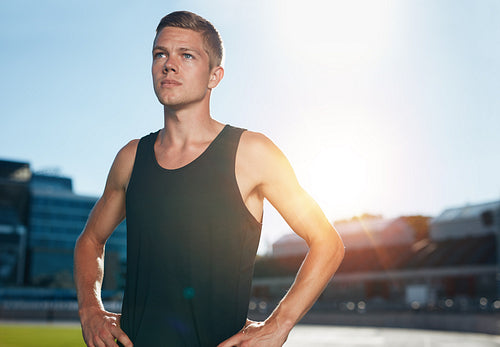 Confident runner on athletics racetrack
