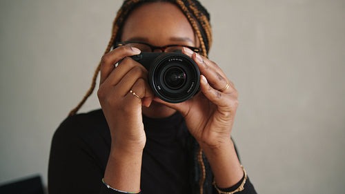 Cheerful female photographer capturing pictures with a dslr camera