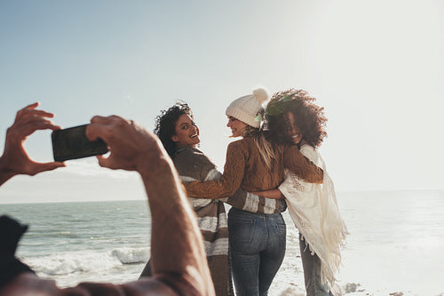 Man taking a picture of friends on road trip