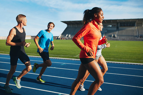 Fit men and women running on a race track