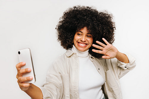 Beautiful woman with curly hair having a video call on a smartphone
