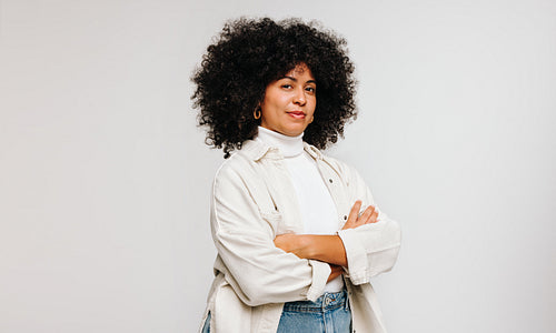 Confident woman with an Afro hairstyle standing in a studio