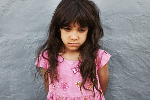 Little girl standing looking upset