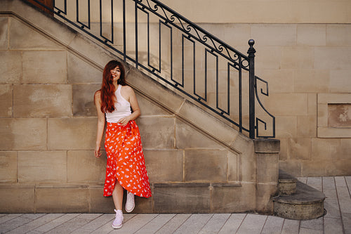 Young woman standing next to an old city building