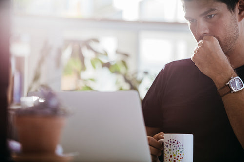 Serious male executive looking at laptop