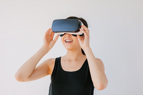 Happy young woman in VR headset looking away