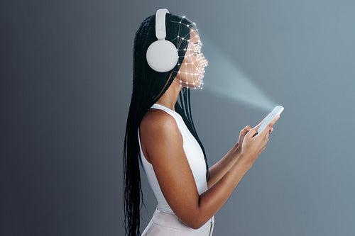 Facial recognition for smartphone access. Woman scanning her face to unlock her mobile device