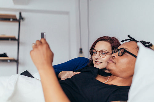 Couple in bed looking at smart phone