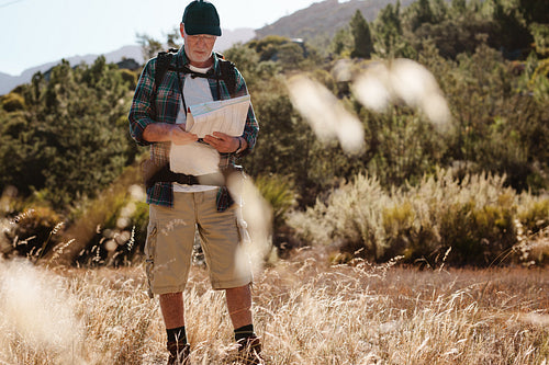 Senior hiker using map