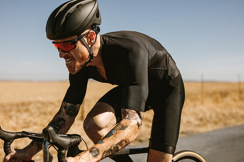 Cyclist riding bike on countryside highway