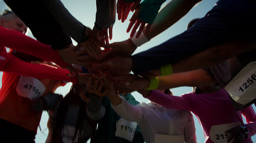 Runners huddle hands for team spirit