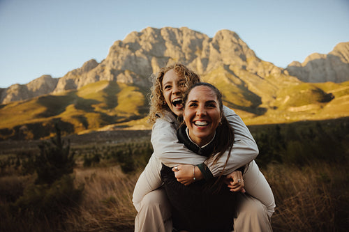 Women laughing outdoors with mountain backdrop