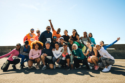 Cheerful running club group photo under the bright blue sky