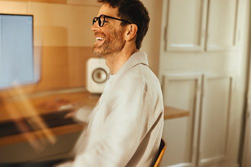 Casual business man laughs at his desk in an office workspace
