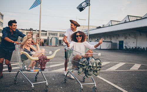 Young friends having fun on a shopping trolleys