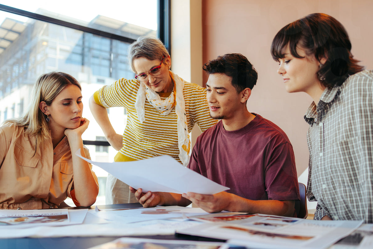 College students and a teacher reviewing feedback on assignments in a ...