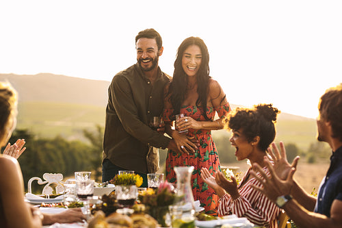 Excited couple announcing their pregnancy at a party