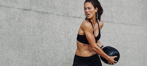 Fitness woman doing workout holding a medicine ball