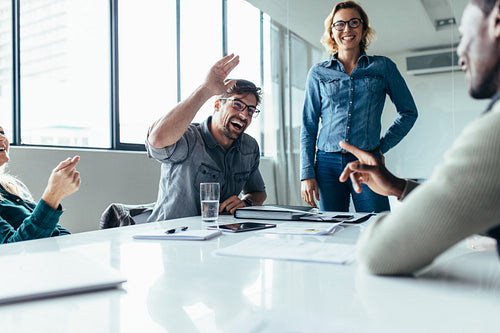 Man inviting for high five during business meeting