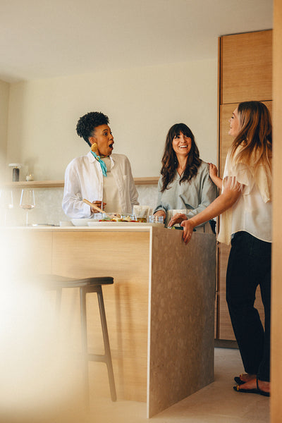 Group of women enjoying a friendly gathering at a modern kitchen counter