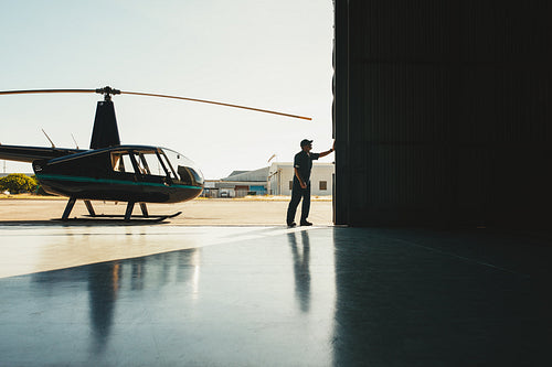 Mechanic opening the door of a airplane hangar